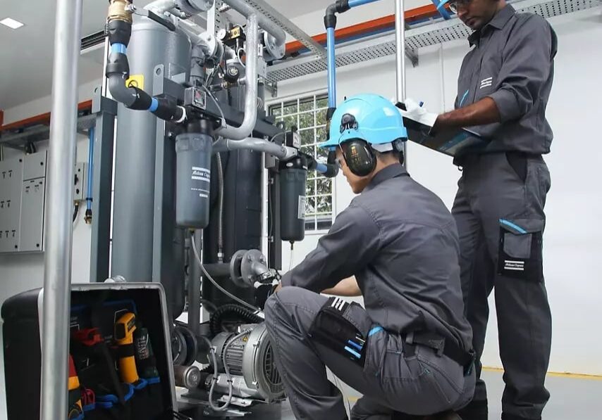 An Anglian engineer servicing an Atlas Copco rotary screw compressor
